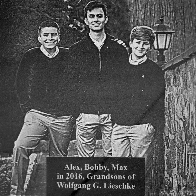 Engraving of three brothers smiling for a photograph on a panel at the Maze of Honor