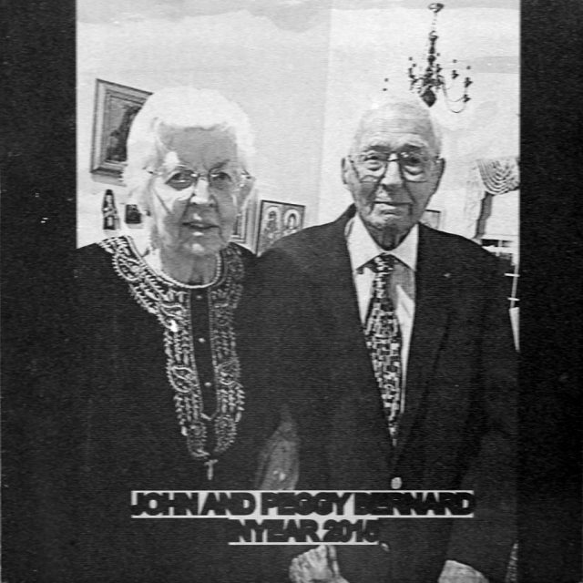 Engraving of elderly man and woman linked arm in arm smiling on a panel at the Maze of Honor