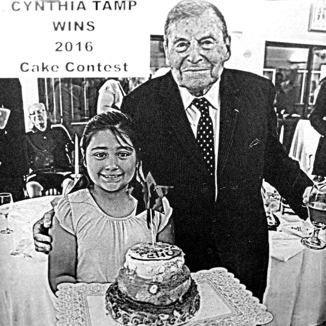 History of Humanity in Granite founder Jacques Istel, a smiling elderly man, with young girl holding a cake