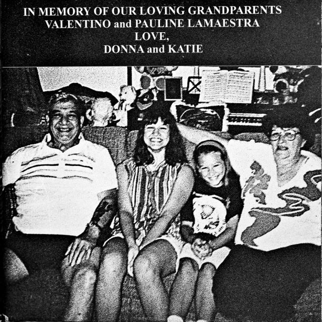 An elderly man and woman sit on either side of their two female grandchildren