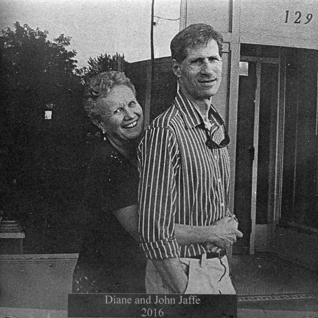 Woman with curled bobbed hair with arms wrapped around man in striped button up shirt engraved onto marble panel for Maze of Honor