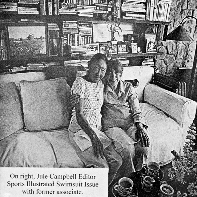 Engraving of two elderly women sitting on a couch in a home with a book case filled with books in the background