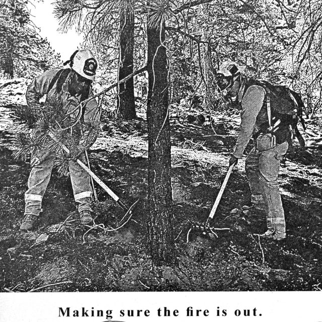 Engraving of two firefighters digging at the base of a tree on marble panel at the Maze of Honor