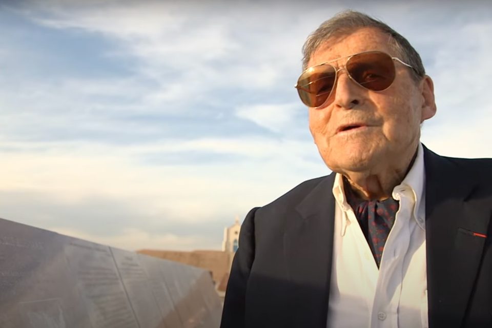 Elderly man wearing dark aviator sunglasses and a smart sport coat