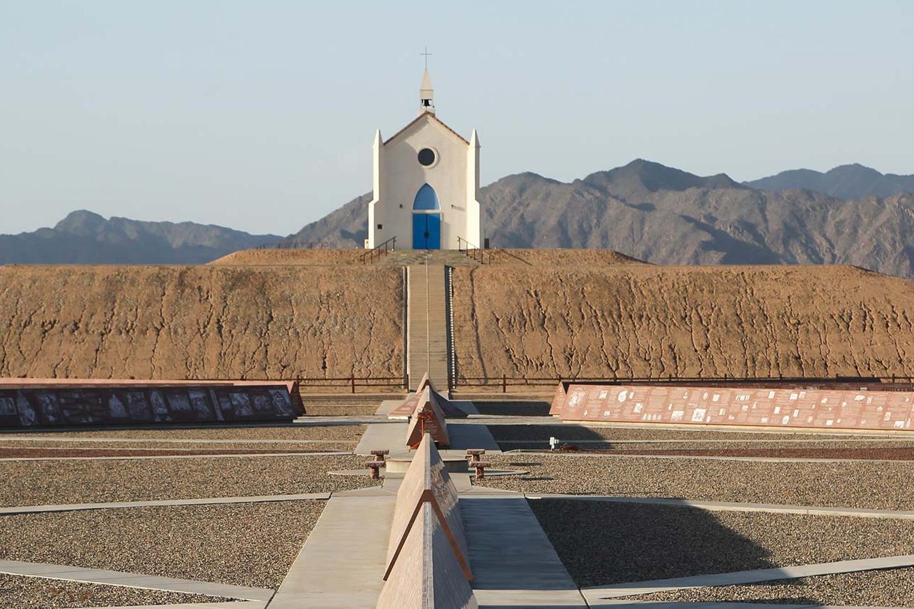 The Church on a Hill atop the Hill of prayer behind a section of the etched Red Missouri granite monuments at the History of Humanity in Granite