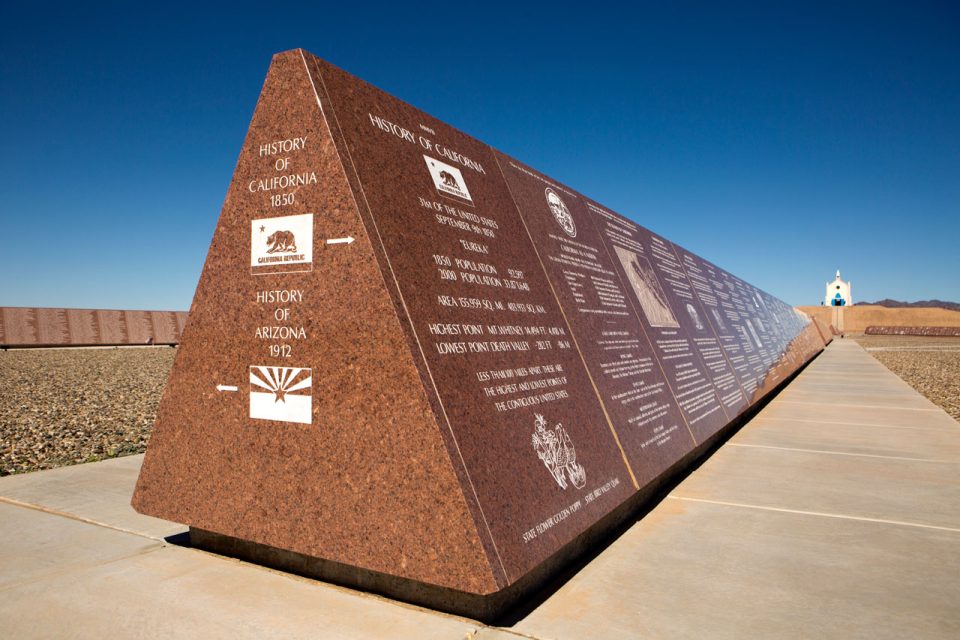 Missouri Red granite monument etched with the History of the California and the History of Arizona with the Church on the Hill in the background