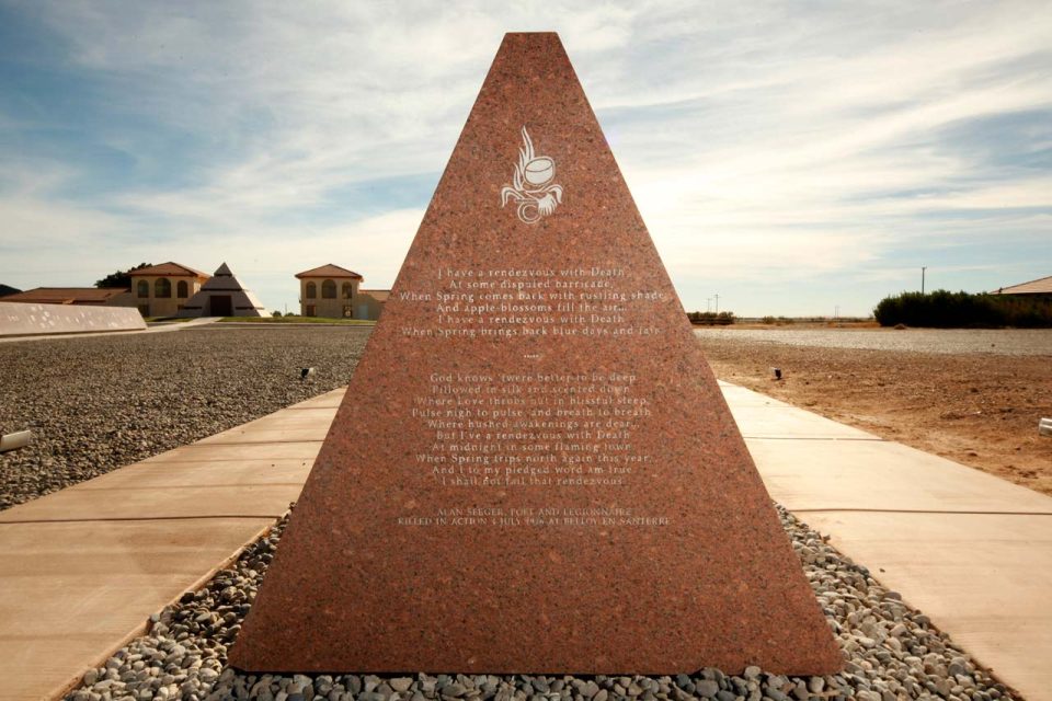History of Humanity in Granite Missouri Red granite monument inscribed with French with the pyramid at the Center of the World in the background