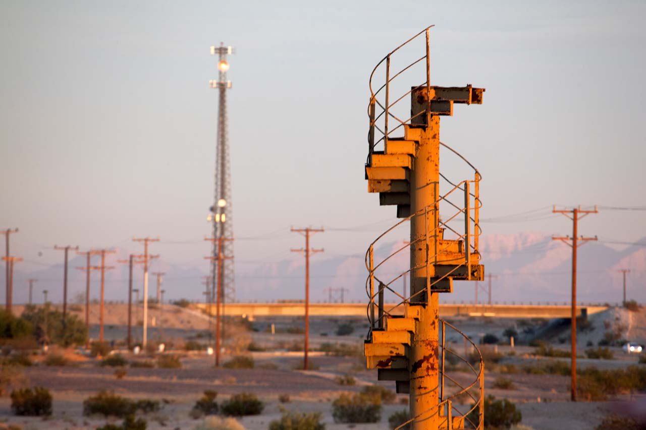 Spiral stairs which were a section of the original stairway of the Eiffel Tower with mountains and powerlines in the background