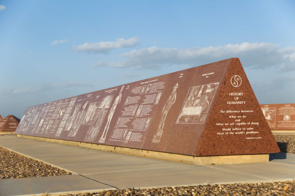 Missouri Red granite monument depicting the History of Humanity etched with quotation from Mahatma Gandhi and Renaissance works of art
